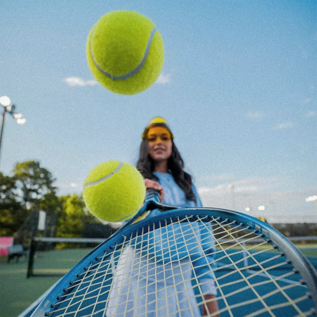 tennis woman smiling with a racket and balls of tennis