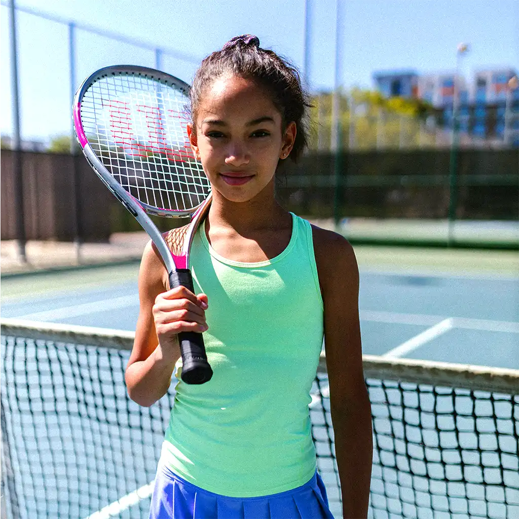 black little girl looking at the camera with her racket of tennis