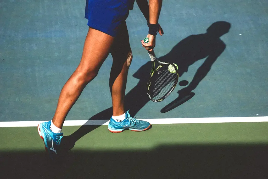 tennis woman on a blue tennis court ready to play