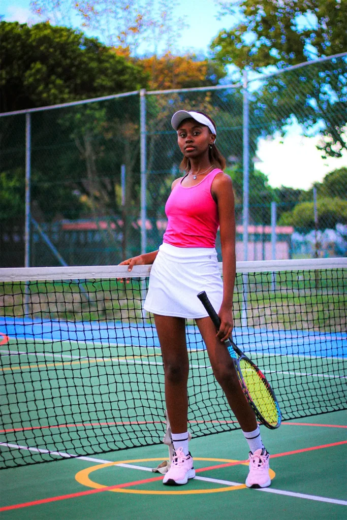 black tennis woman wearing electric colour outfit on a tennis court